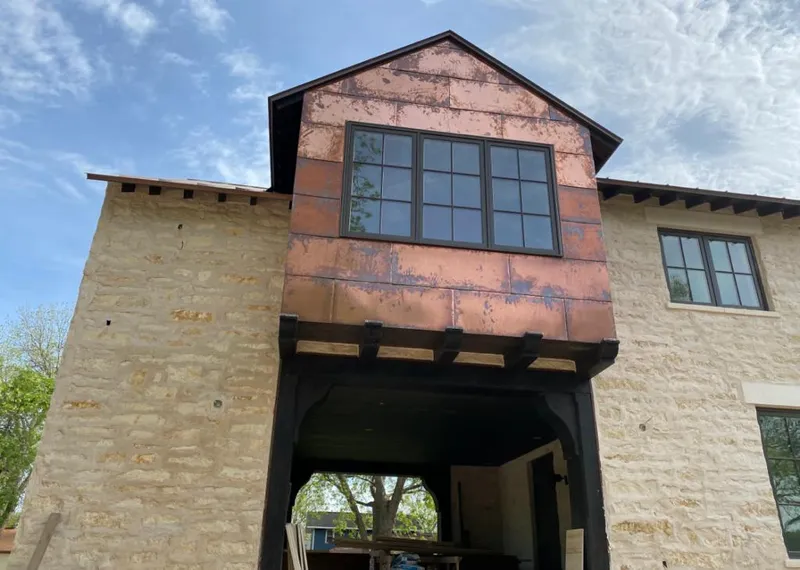 Copper metal panel facade on a stone building for Skylight Installation in Lake Arbor