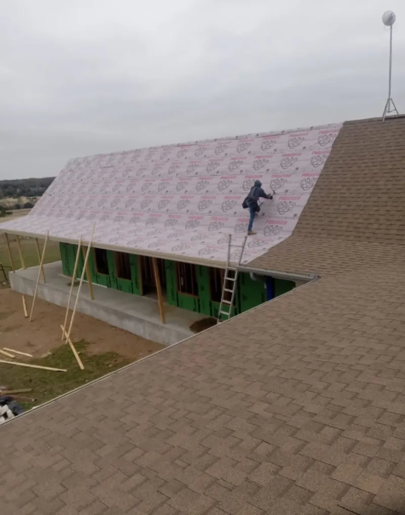 Worker preparing underlayment for a metal roof installation in Lake Arbor